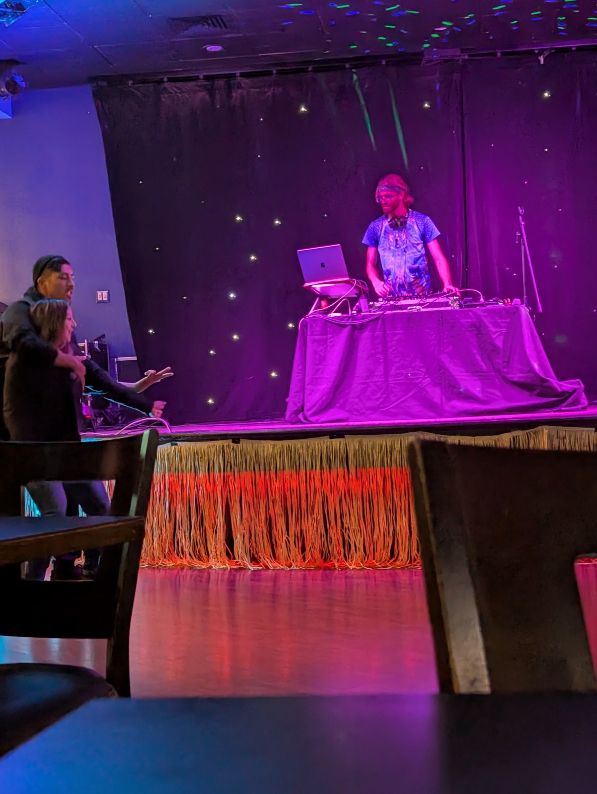 Kieran Specht running a lighting console during a show, dance floor visible in the background